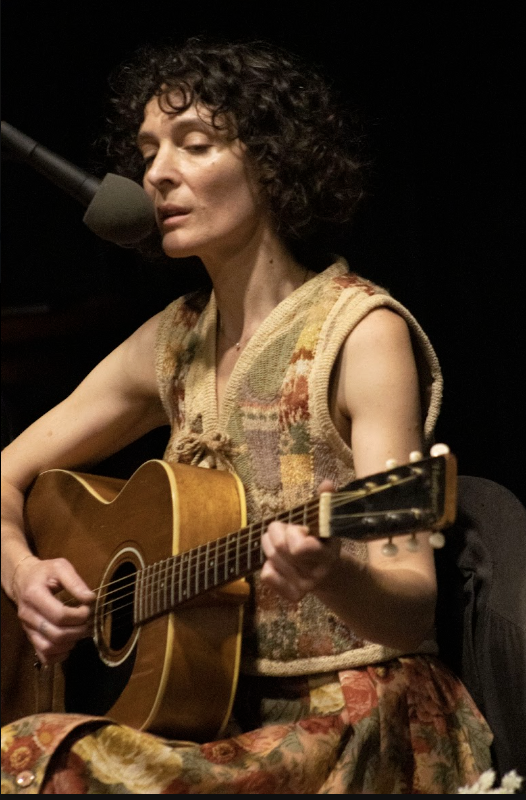 lovage sharrock seated playing guitar